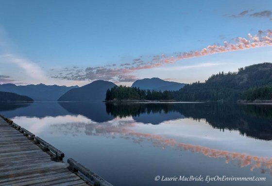 Wharf with water, mountains and sunrise in distance